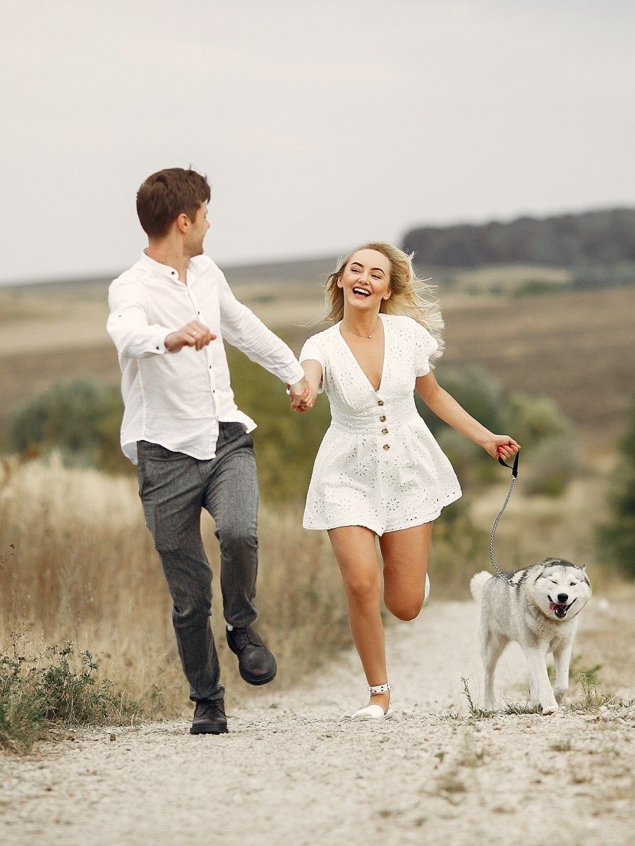 Couple in a field. Pair with a dog. Girl in a white dress